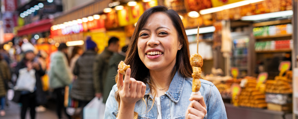 Woman holding skewers at a food market