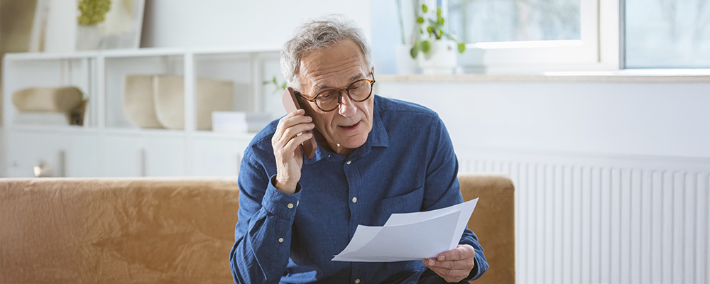 Man on the phone holding paperwork
